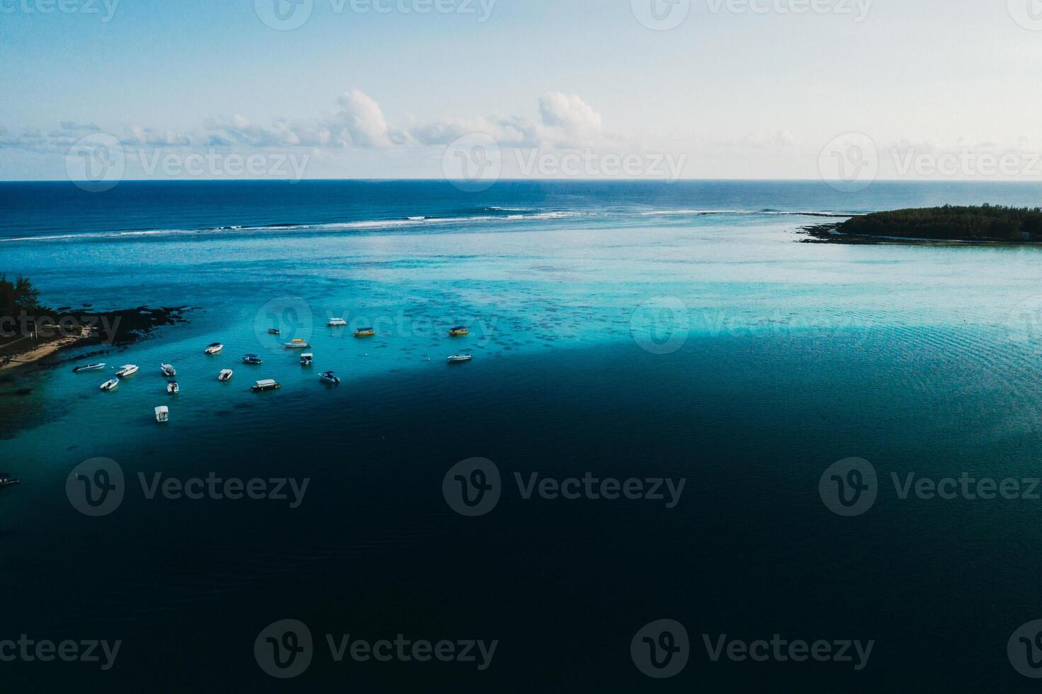 Aerial picture of the east coast of Mauritius Island. Beautiful lagoon of Mauritius Island shot from above. Boat sailing in turquoise lagoon photo