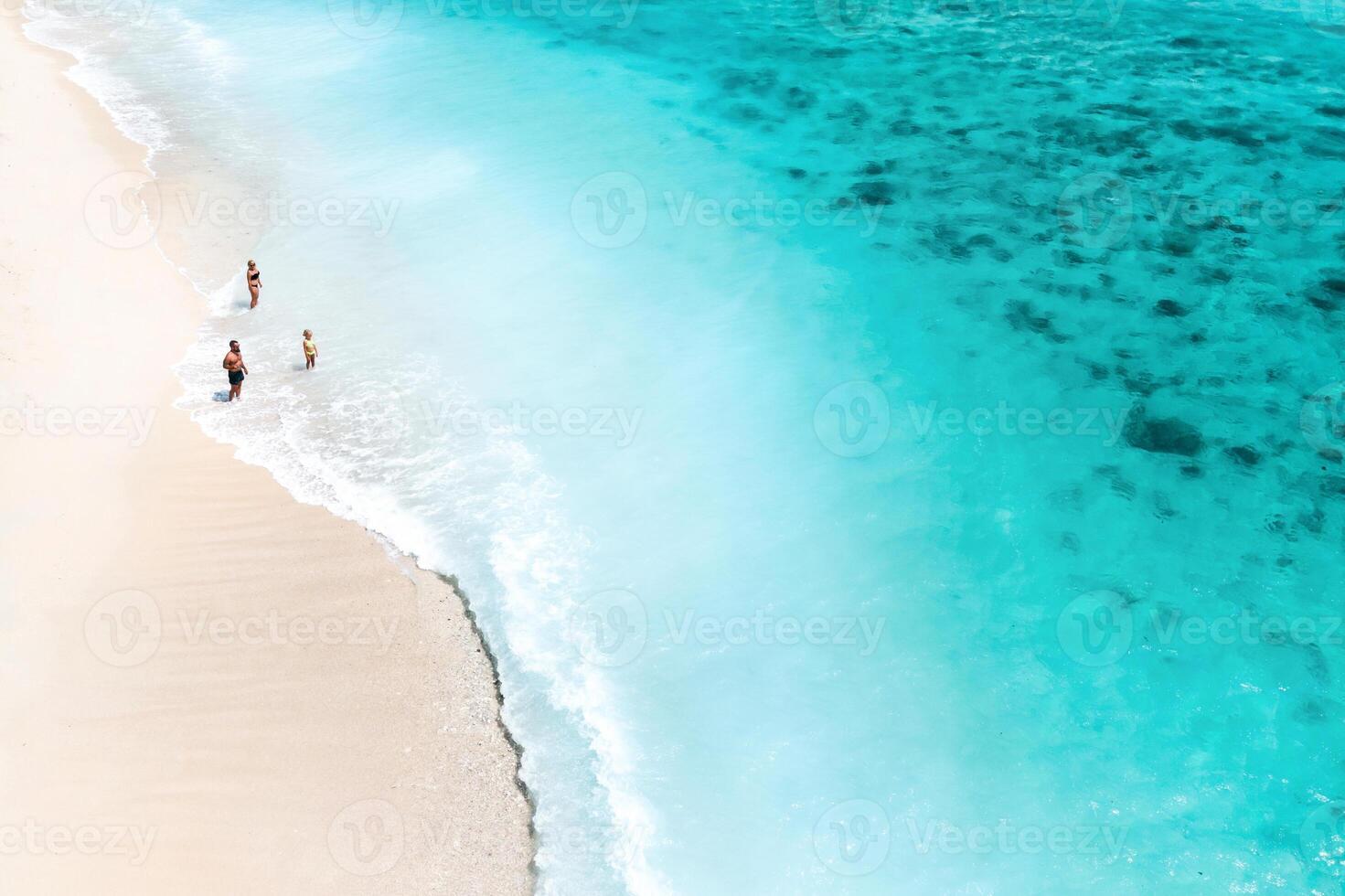 A family stands on Le Morne beach in the Indian Ocean on the island of Mauritius photo