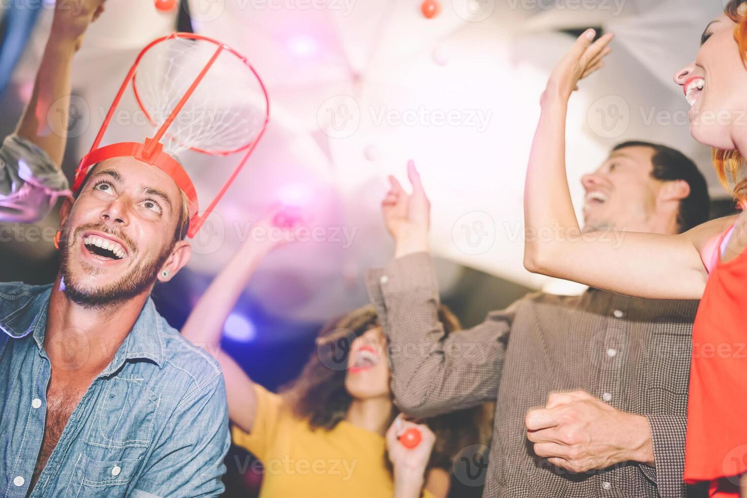 Group happy friends playing funny basketball games in cocktail bar - Young millennia people having fun during weekend holidays - Youth culture lifestyle concept photo