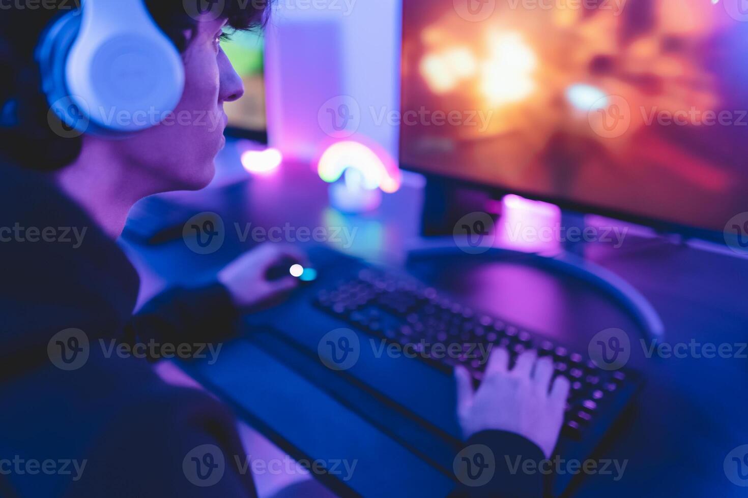 joven jugador teniendo divertido jugando en línea vídeo juegos con computadora a hogar - juego de azar entretenimiento y tecnología concepto foto