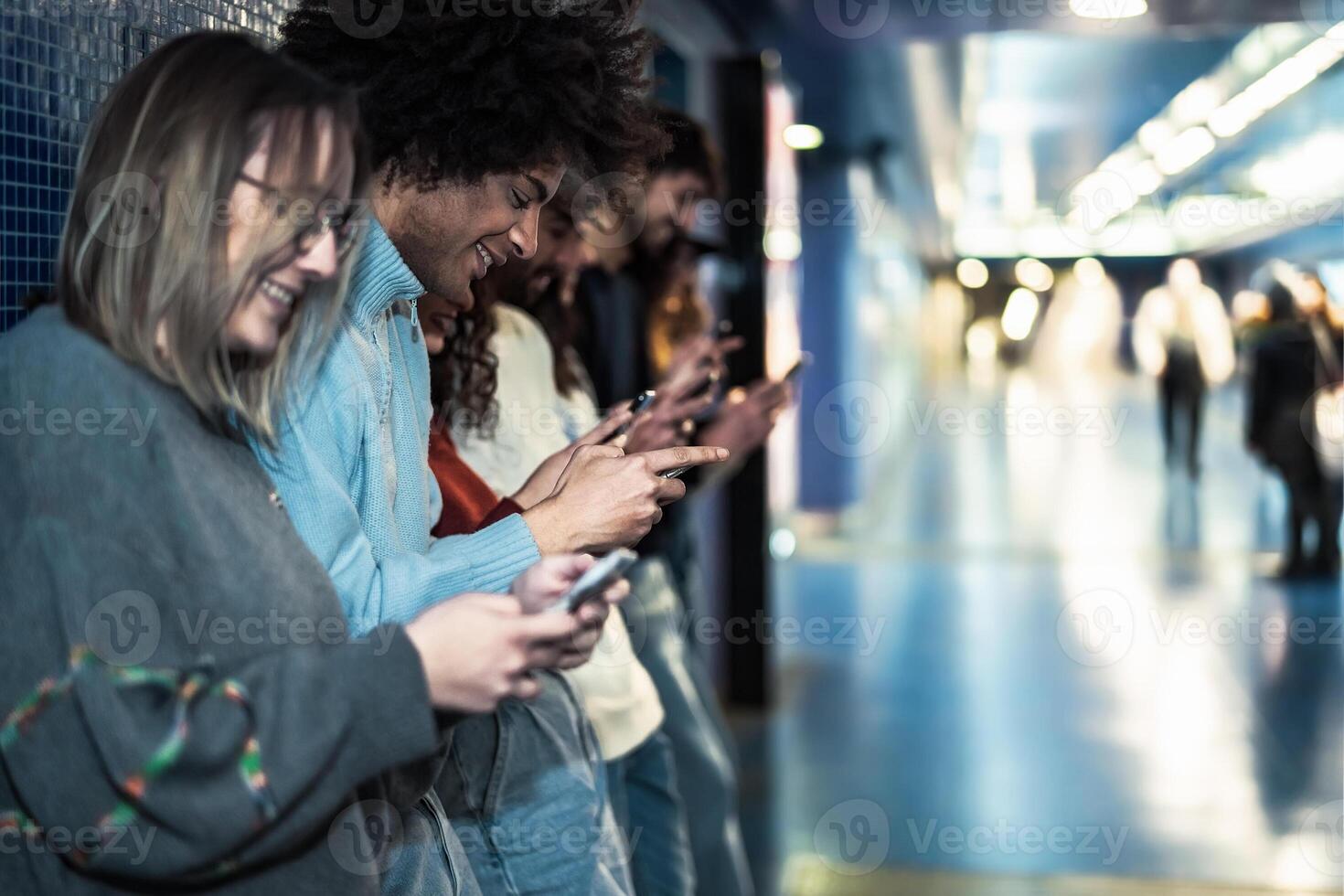 joven personas utilizando móvil teléfono inteligente en subterraneo estación esperando tren - juventud milenario fanático a nuevo tecnología concepto foto