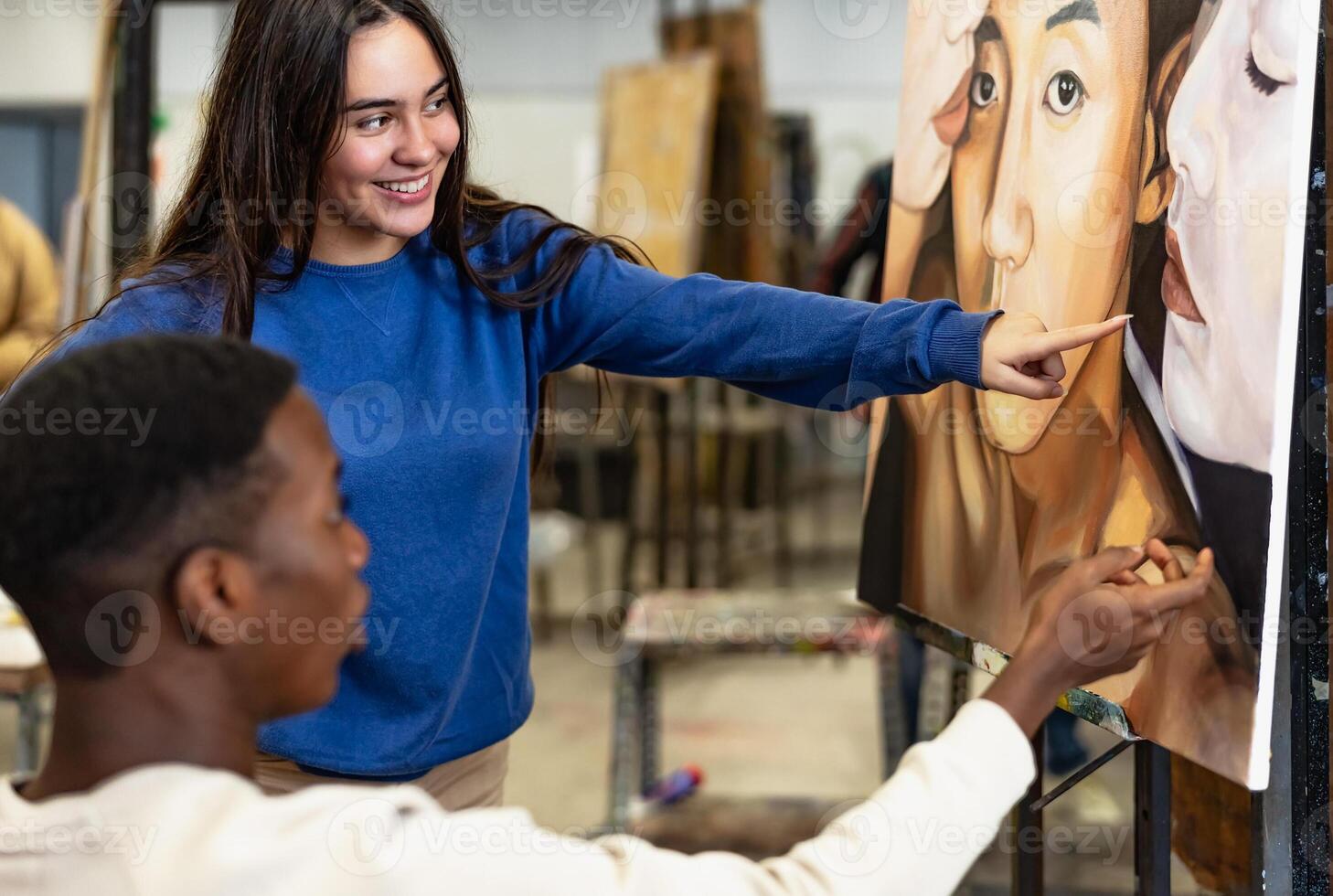 Young multiracial students learning about painting on canvas during lesson in faculty of arts university - Education and culture concept photo