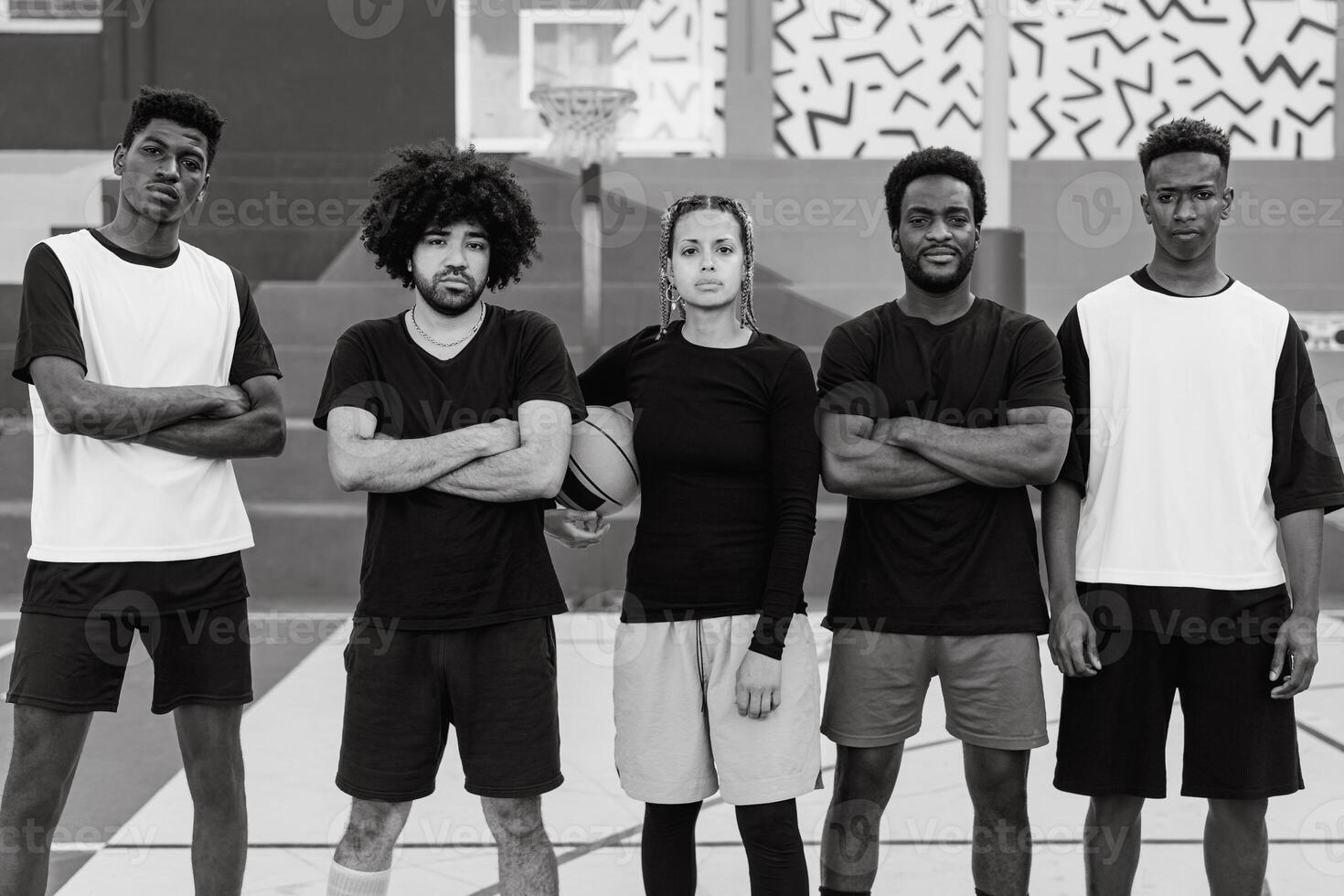 Group of multiracial people having fun playing basketball outdoor - Urban sport lifestyle concept - Black and white editing photo
