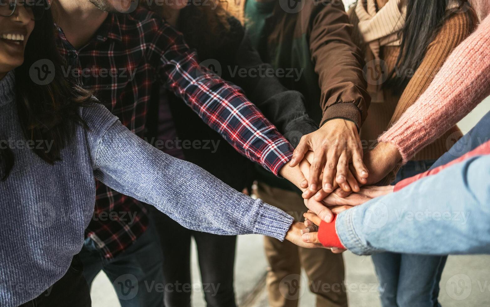 Happy young friends having fun stacking hands together outdoor - Youth people millennial generation concept photo