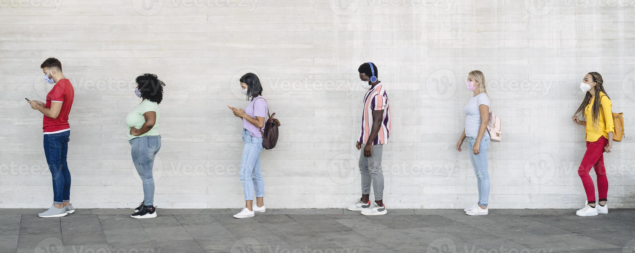 joven personas desde diferente culturas y carrera esperando en cola fuera de tienda mercado mientras acuerdo social distancia - corona virus untado prevención concepto foto