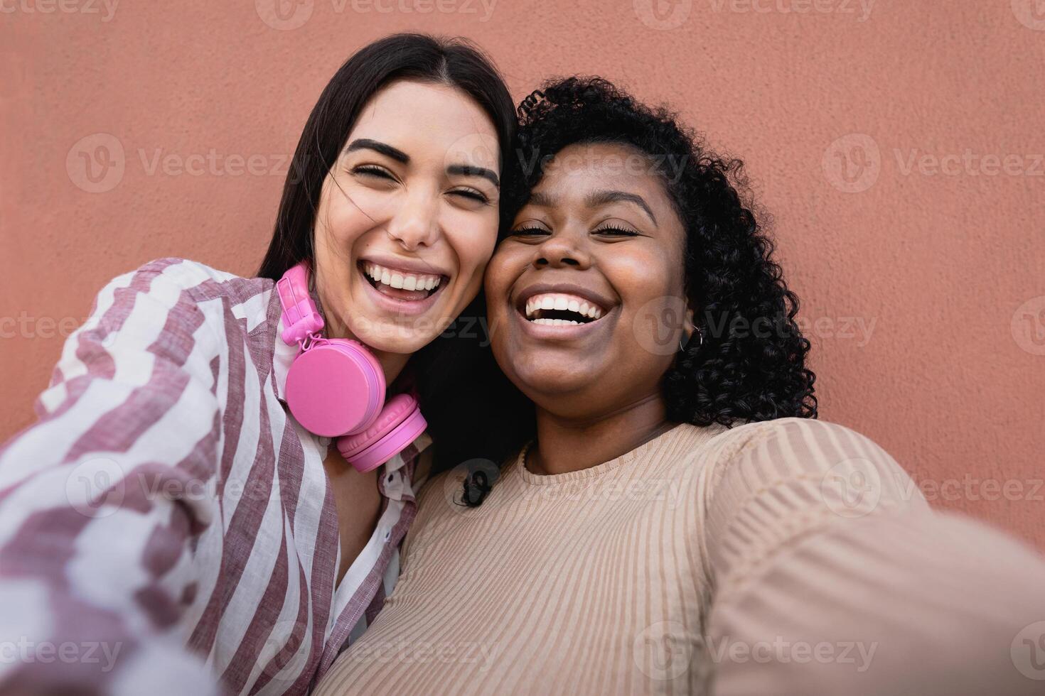 Happy Hispanic friends having fun taking selfie with mobile smartphone outdoor - Technology and social media concept photo