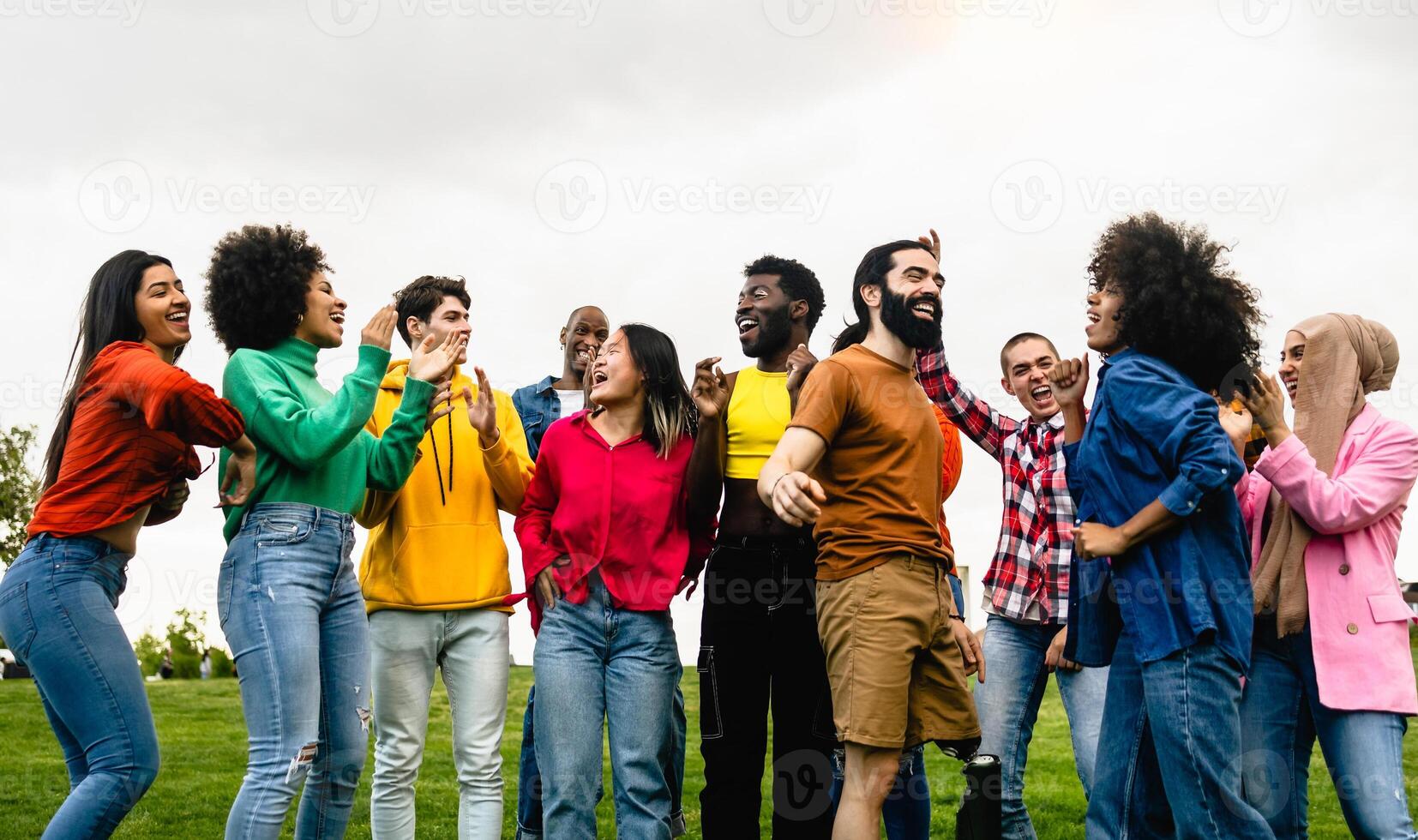 Young multiracial friends having fun dancing together in park - Friendship and diversity concept photo