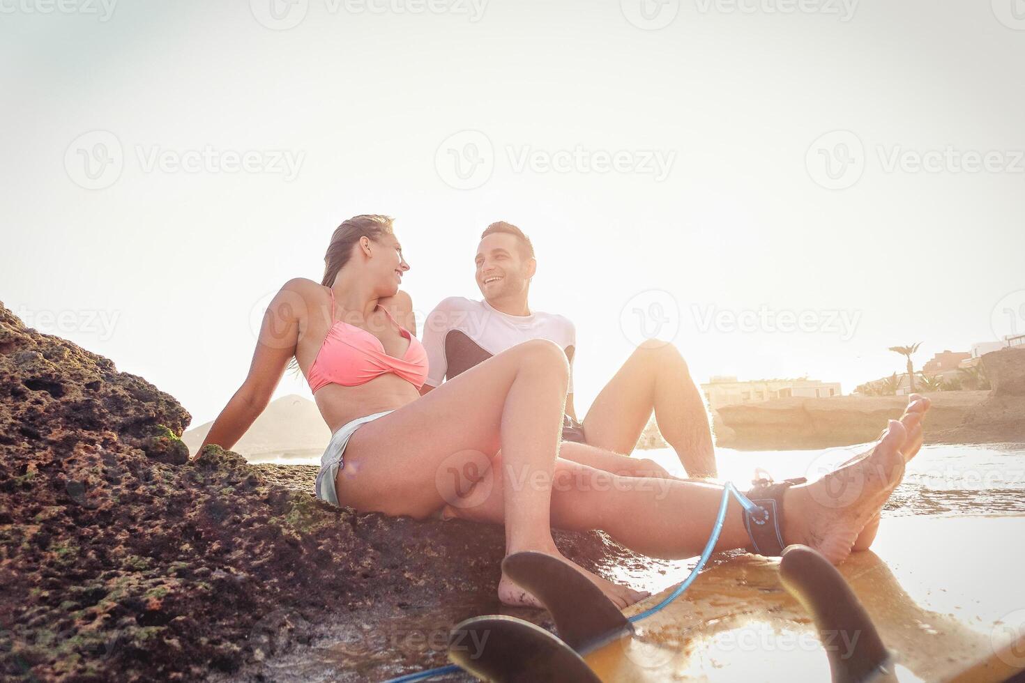 Happy sportive couple having a break looking each other and laughing - Sporty lovers having tender moment sitting on a rock - Sport, extreme, relationship love and healthy lifestyle concept photo