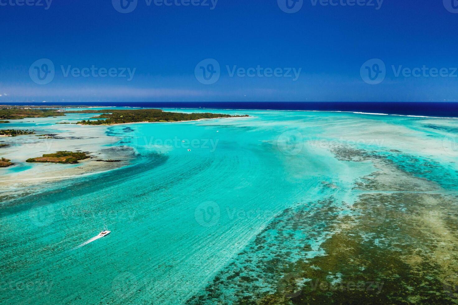Aerial picture of the east coast of Mauritius Island. Beautiful lagoon of Mauritius Island shot from above. Boat sailing in turquoise lagoon photo