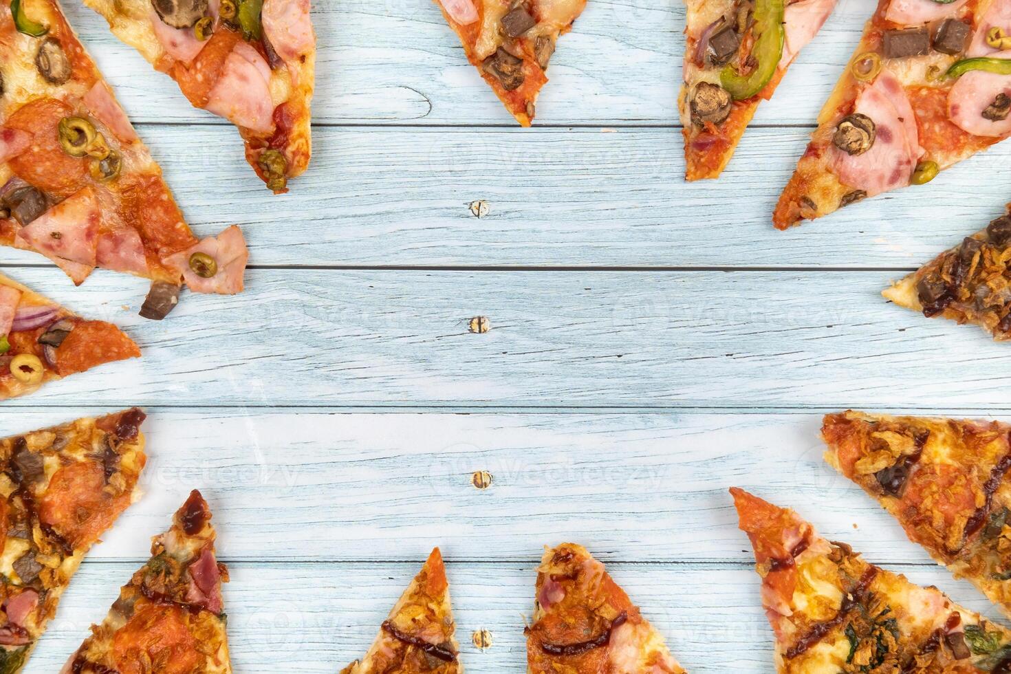 Lots of delicious triangular pizza slices on a blue wooden background photo