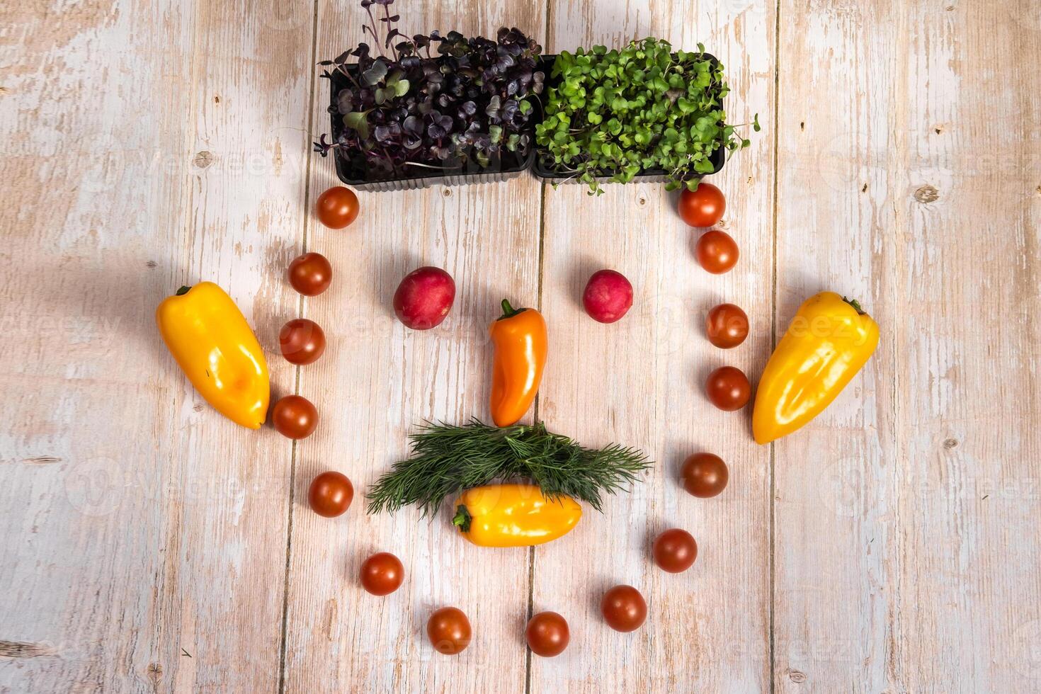 The face of a man made of sliced vegetables on a wooden background photo