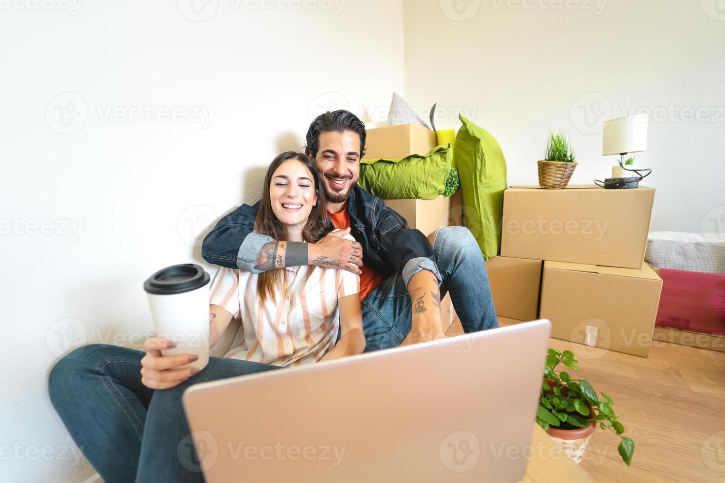 contento joven Pareja Moviente en nuevo hogar primero hora - hombre y mujer teniendo divertido utilizando computadora siguiente caja de cartón caja en nuevo propiedad casa - cambio Departamento día y personas estilo de vida relación concepto foto