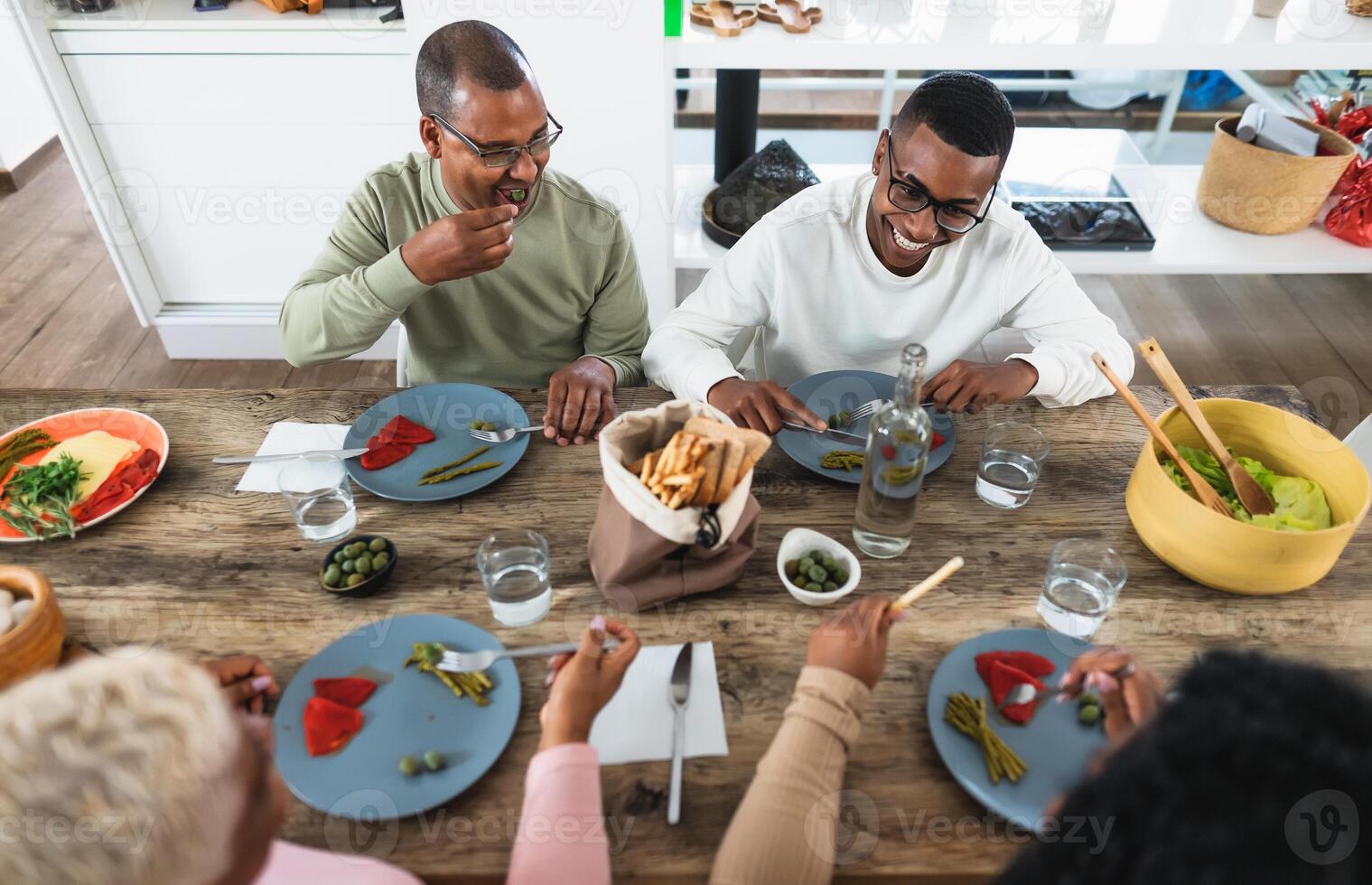 contento negro familia comiendo sano almuerzo juntos a hogar foto