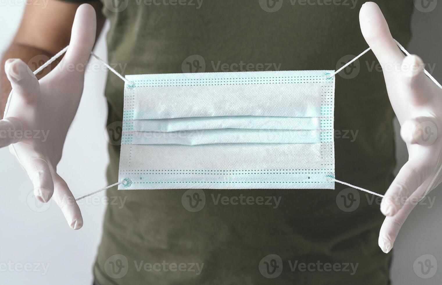 Male hands holding surgical mask against coronavirus - Face mask for preventing corona virus spreading - Health care covid19 and medical protection concept photo