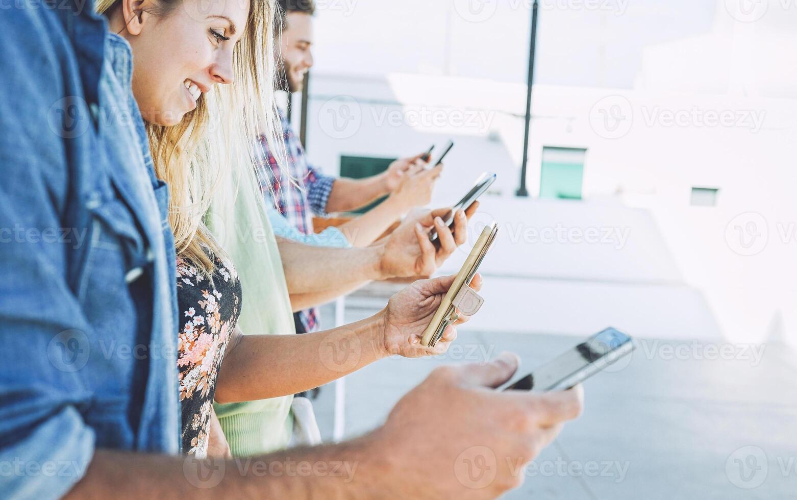 grupo de amigos utilizando móvil inteligente Los telefonos exterior. joven estudiantes teniendo divertido surf en social medios de comunicación red tendencias Generacion fanático a nuevo teléfono inteligente tecnología. juventud fanático concepto foto