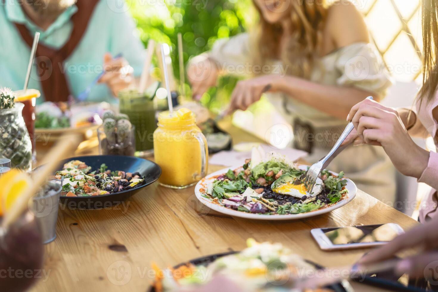 contento amigos almorzando sano comida en desayuno tardío bar restaurante - joven personas teniendo divertido comiendo y Bebiendo batidos Fresco frutas en Clásico bar - salud tendencias estilo de vida concepto foto