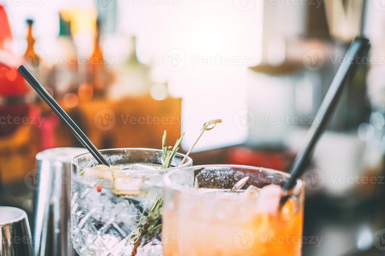 cócteles sirve en bar mostrador preparado con Ginebra, Romero, papel y naranja jugo. beber, la vida nocturna, estilo de vida concepto. atención en parte superior cristal vaso foto