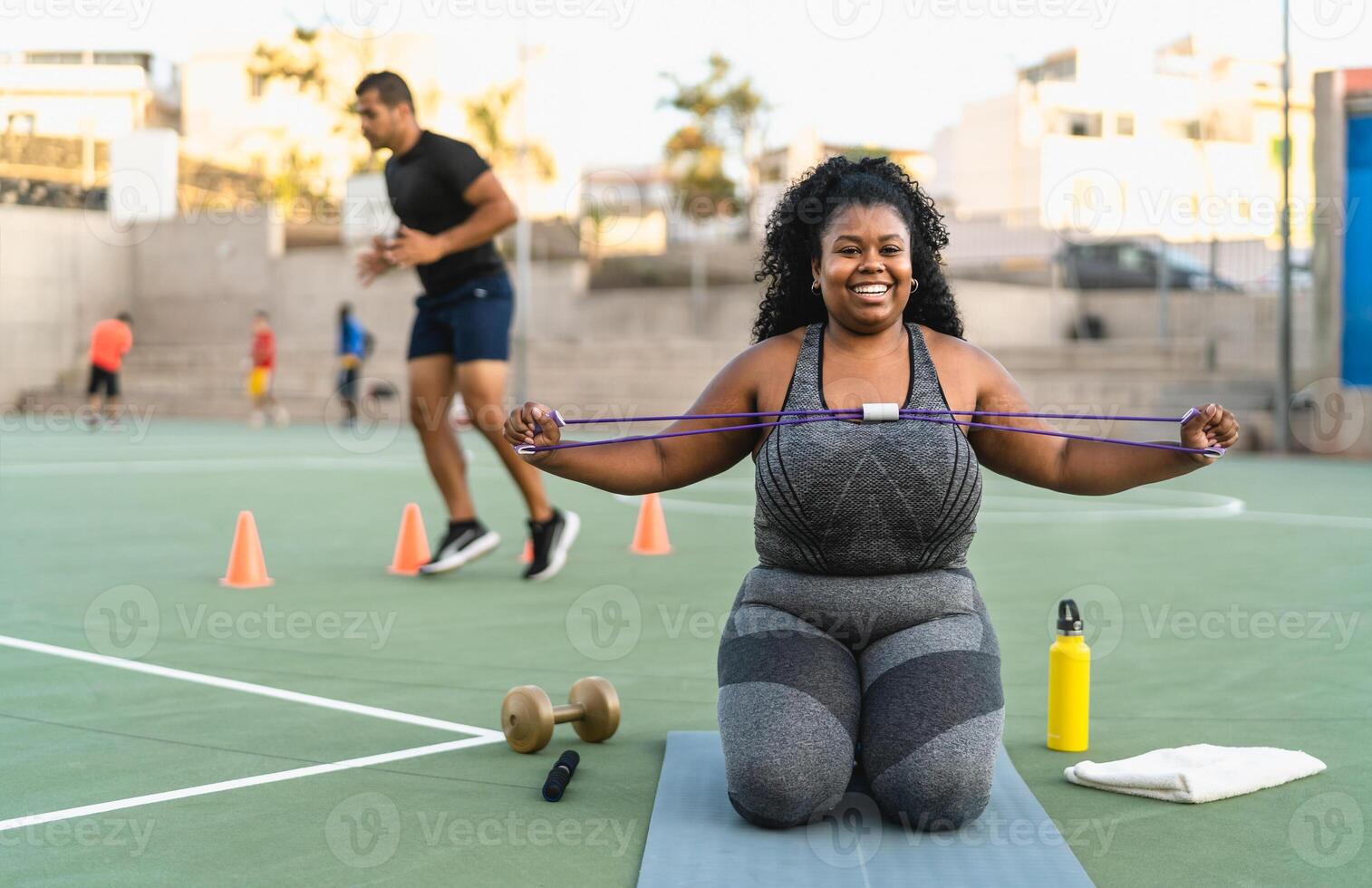 a woman is sitting on a mat working out photo