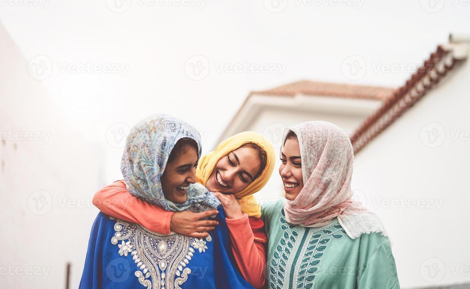 Happy Muslim girlfriends having fun walking outdoor - Arabian girls sharing time and conversation together in the college - People religion culture and friendship concept photo