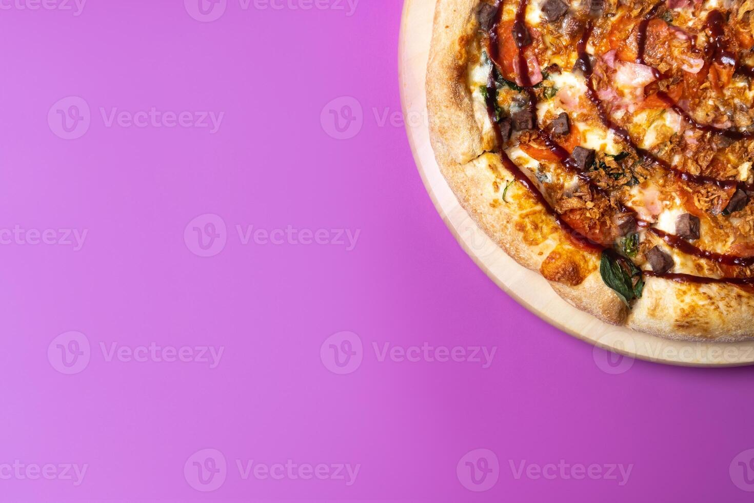 Delicious large pizza with bacon and spinach on a pink background photo