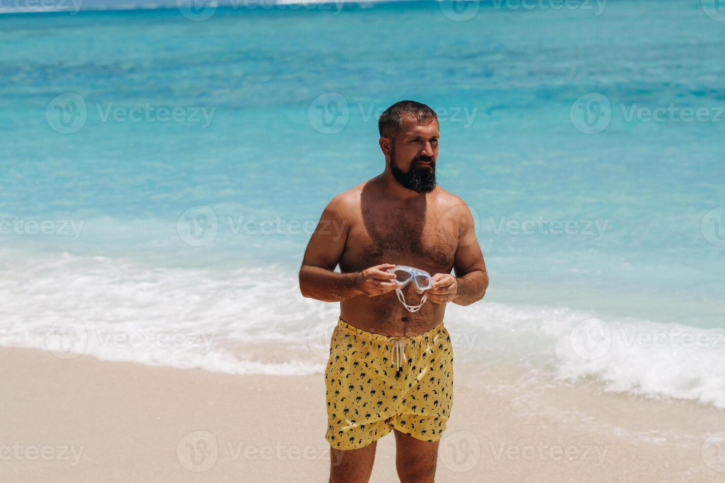 Portrait of an attractive man with a beard on a tropical beach in the Indian Ocean photo