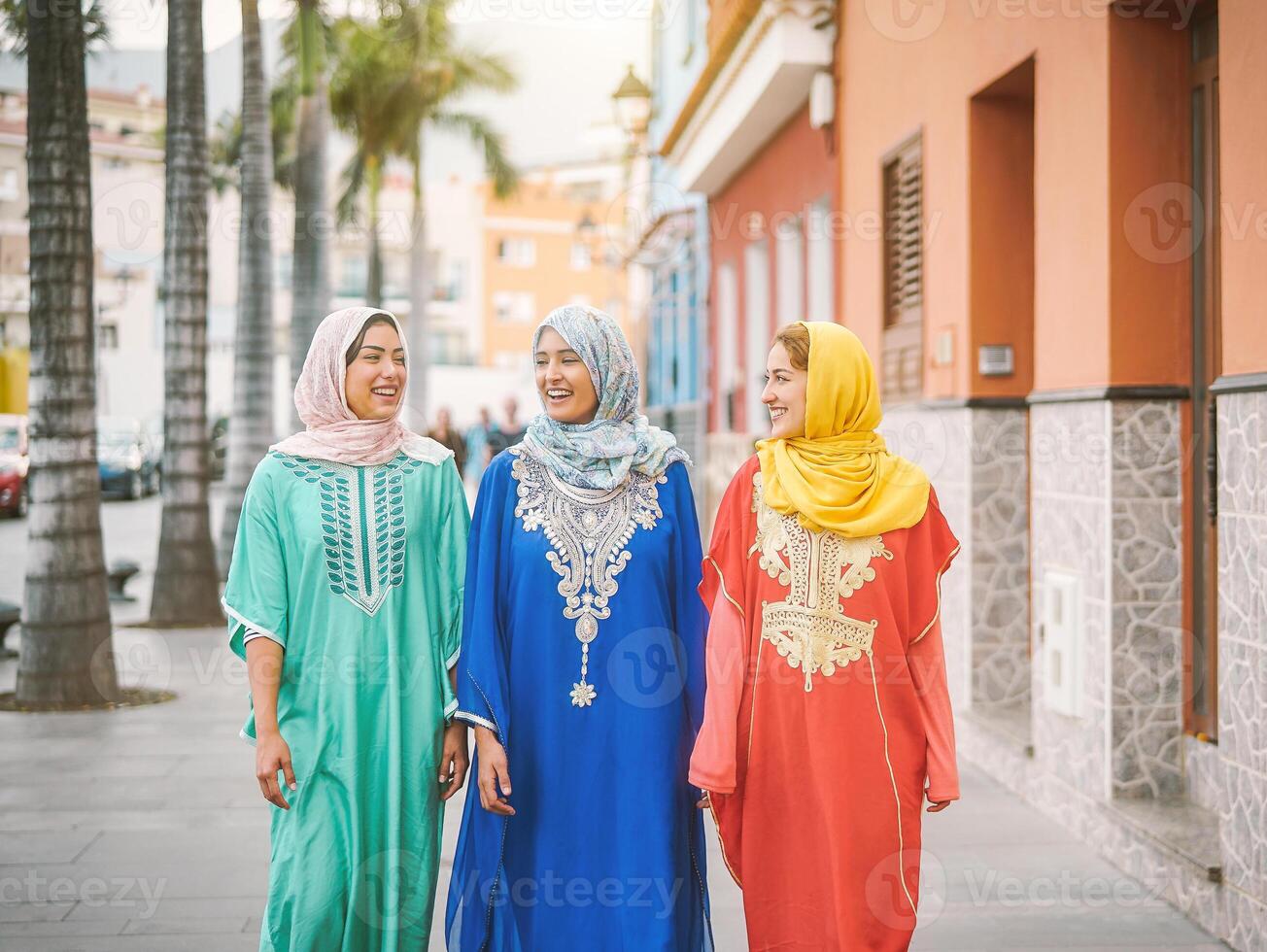 Happy muslim women walking in the city center - Arabian teen girls having fun spending time together outdoor - concept of people, culure and religion photo