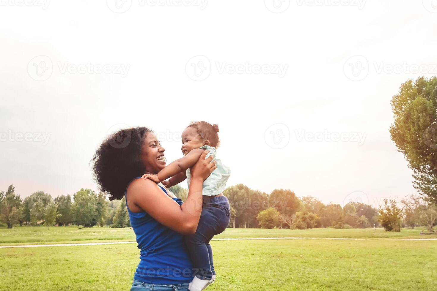 happy mother having fun with her daughter in park outdoor - Loving family enjoying time together - Parents love and mother's day concept photo