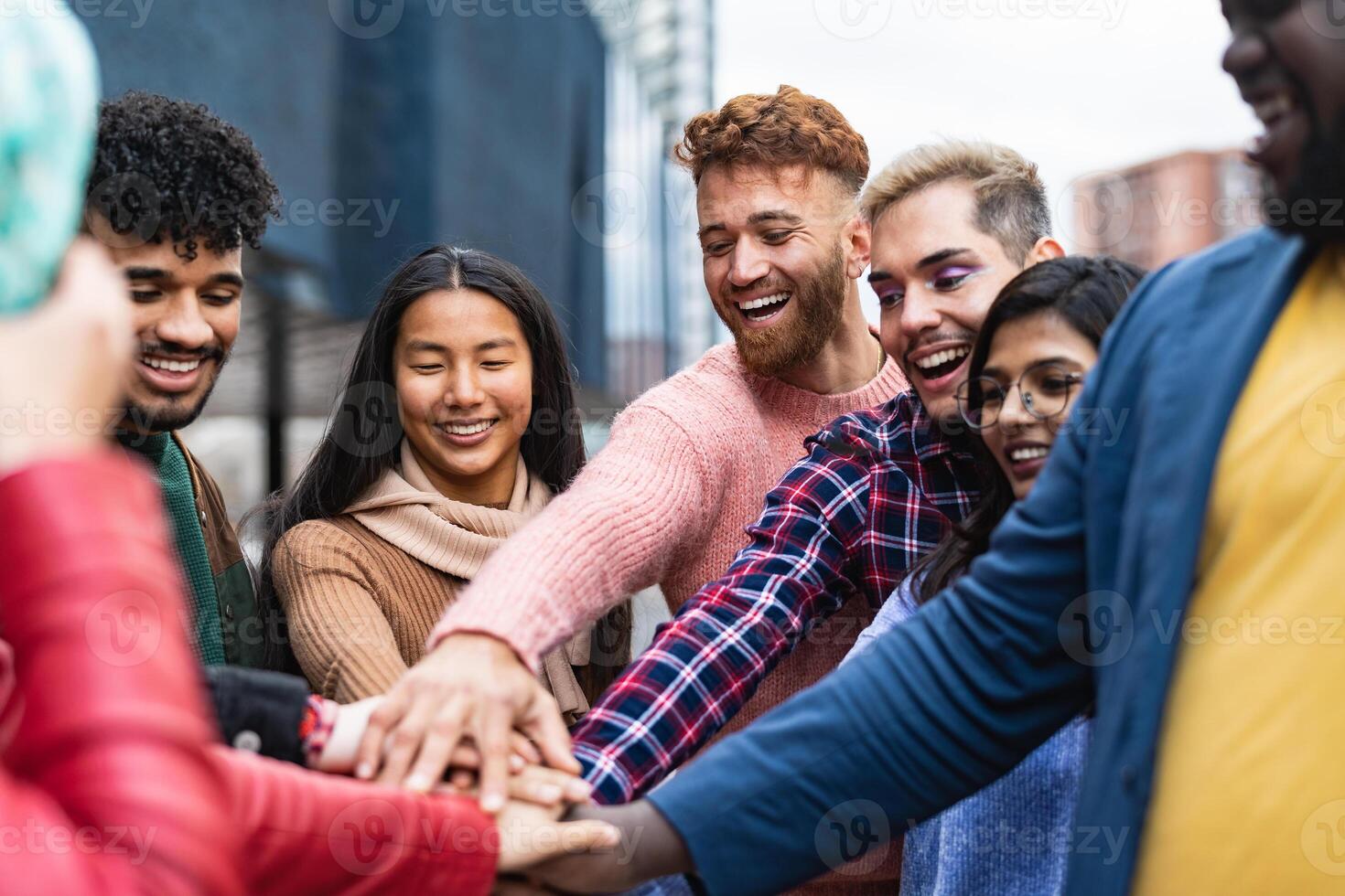 Happy multiracial friends having fun stacking hands together outdoor - Youth people millennial generation concept photo