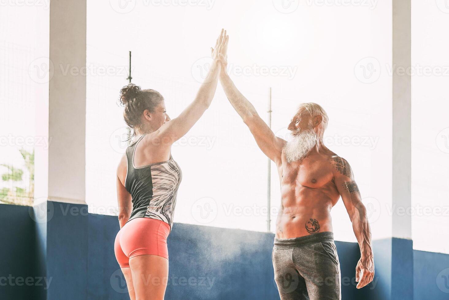 Fitness couple stacking hands in gym wellness club - Happy athletes motivating each other - Concept of people training, fit, empowering and bodybuilding lifestyle photo