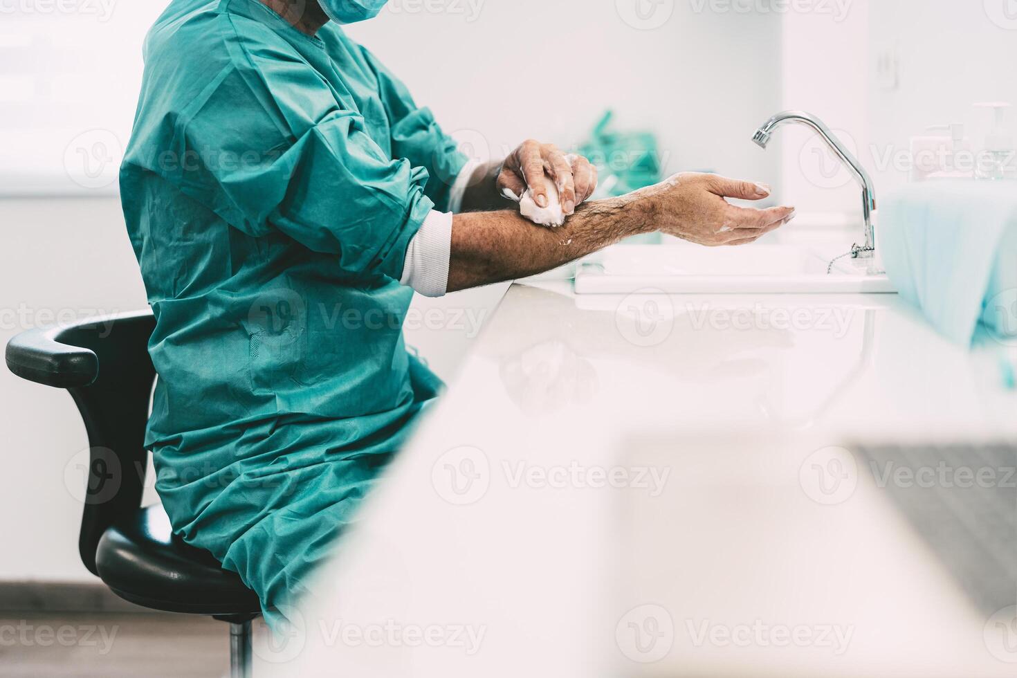 Surgeon washing hands before operating patient in hospital - Medical worker getting ready for fighting against corona virus pandemic - Health care and hygiene concept photo