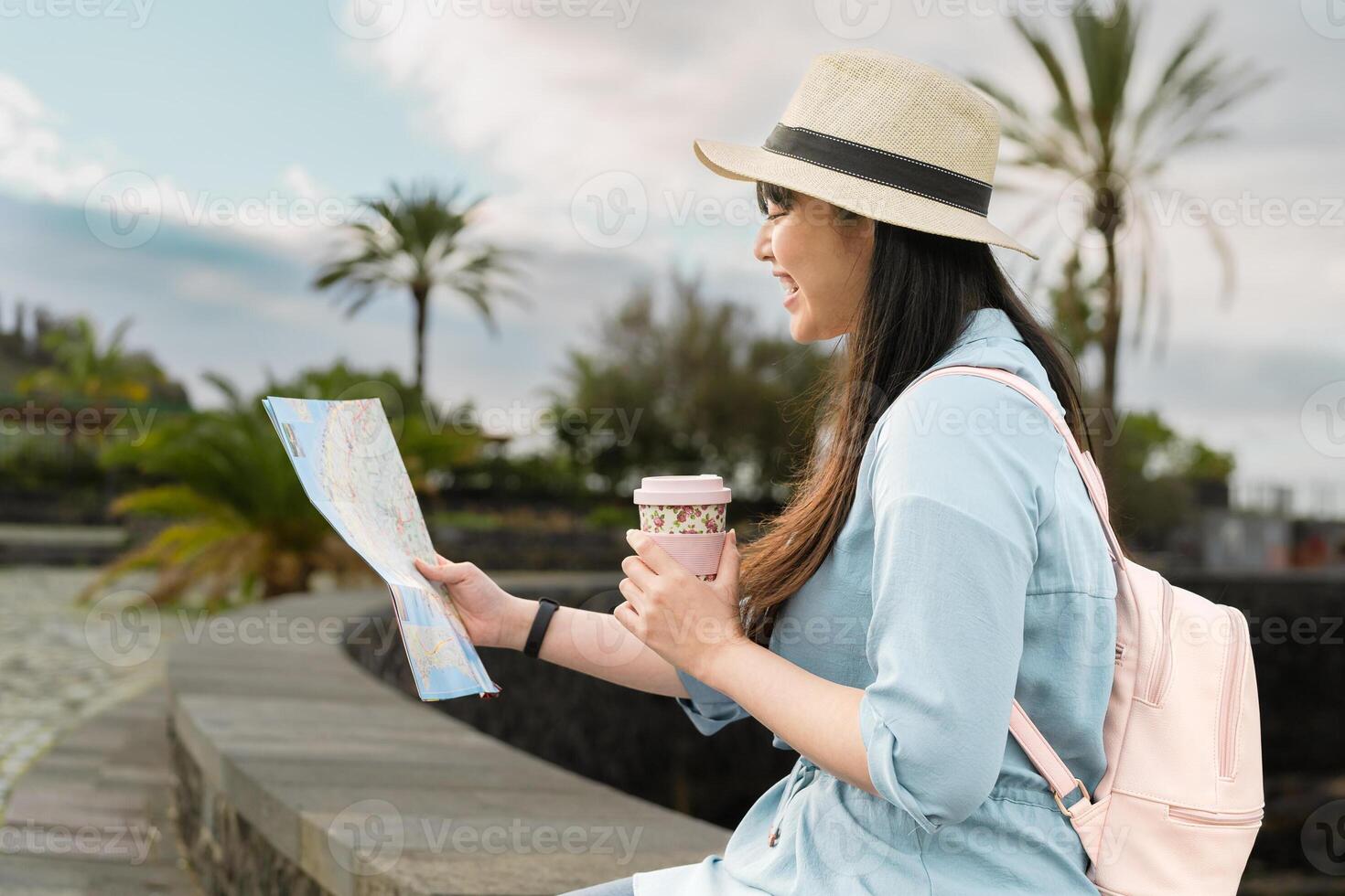 Happy travel Asian girl looking map discovering new places during city tour photo