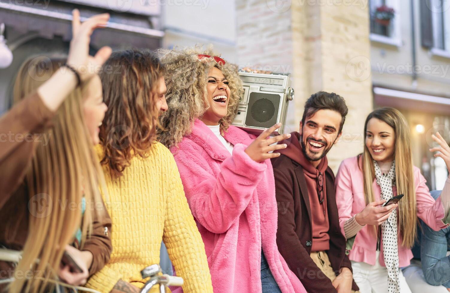 Group friends having fun listening music with vintage boombox - Happy young people making party in city outdoor  - Youth culture and millennial lifestyle concept photo