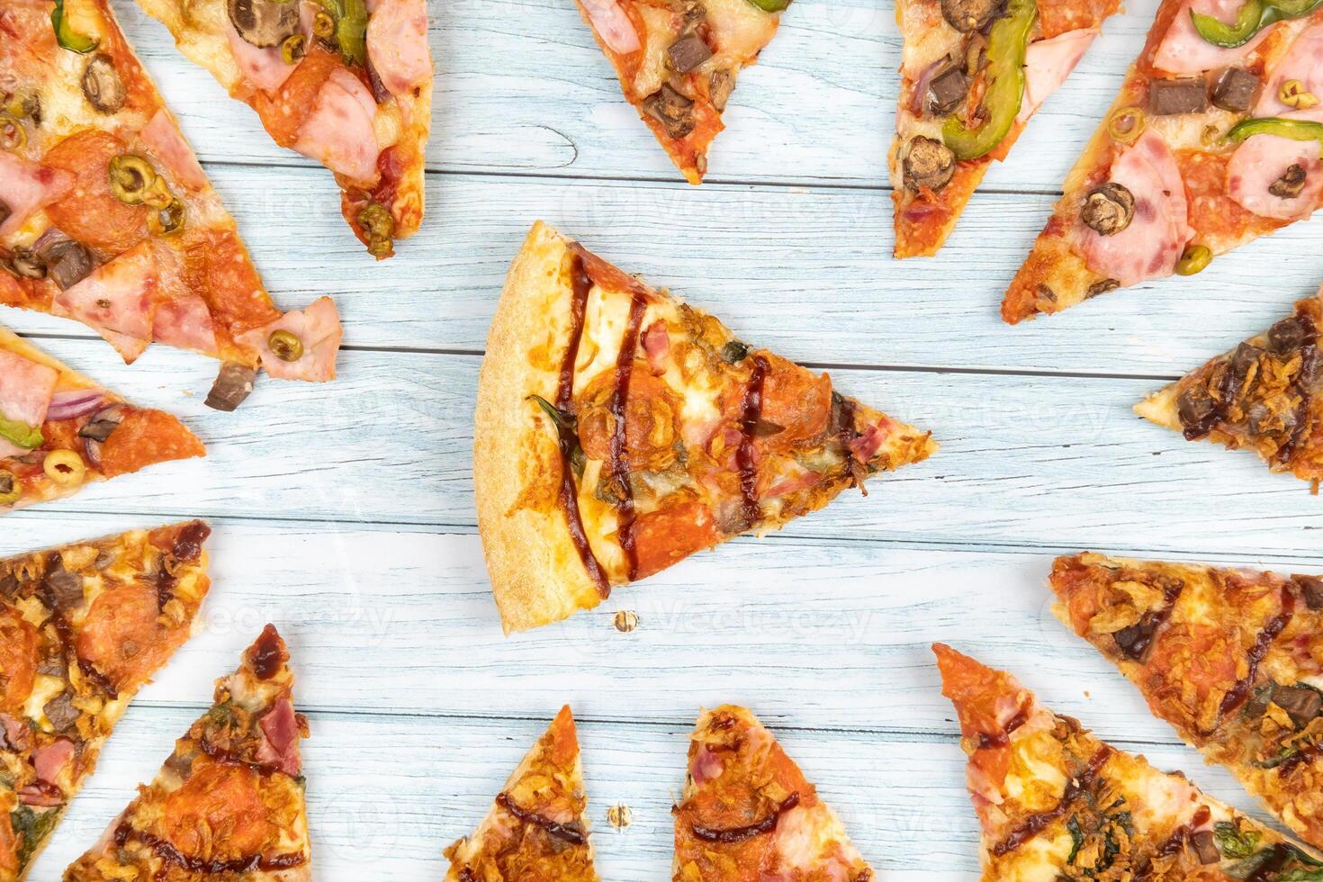 Lots of delicious triangular pizza slices on a blue wooden background photo