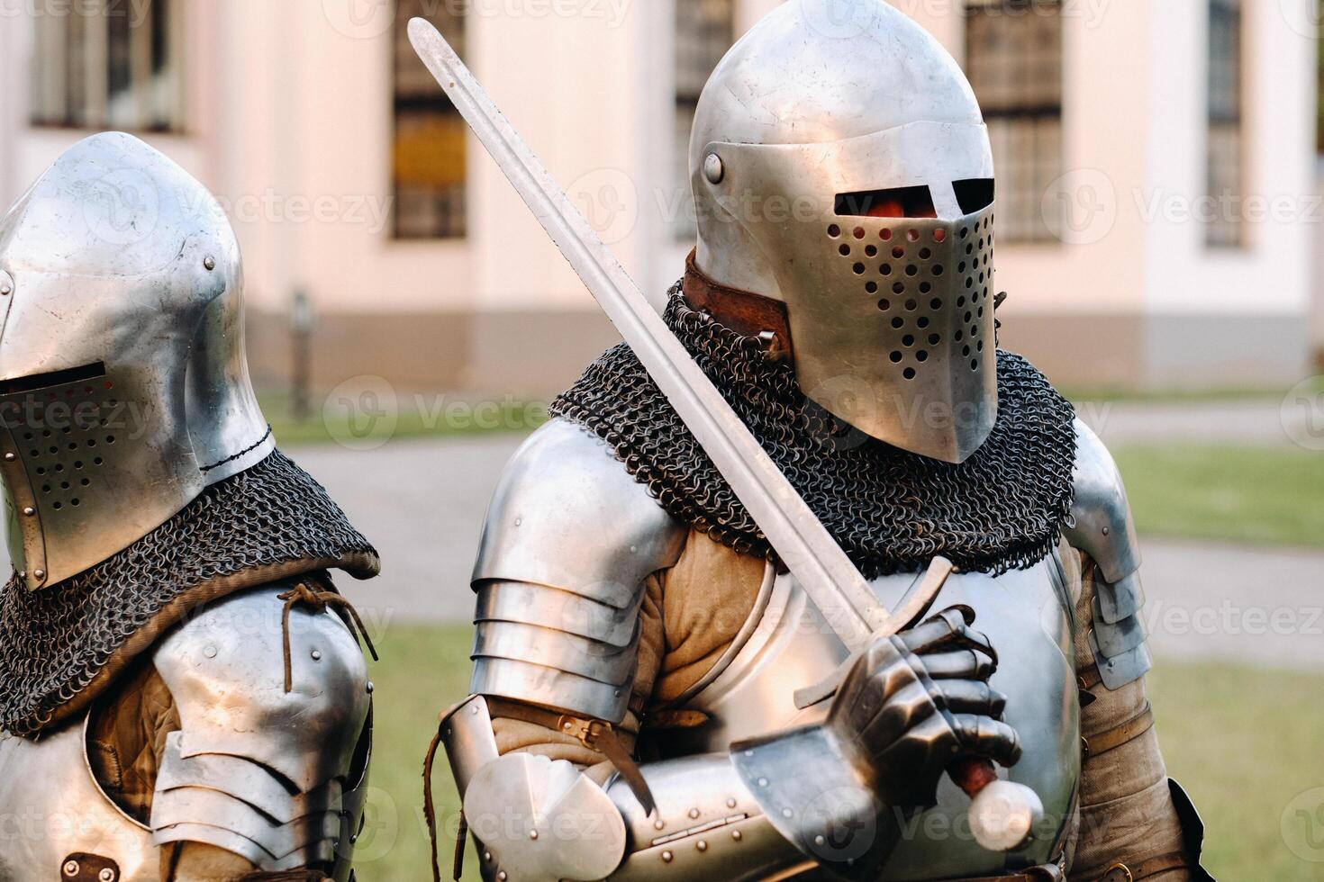 Two knights in armor on the background of a medieval castle.A medieval concept.Metallic texture photo