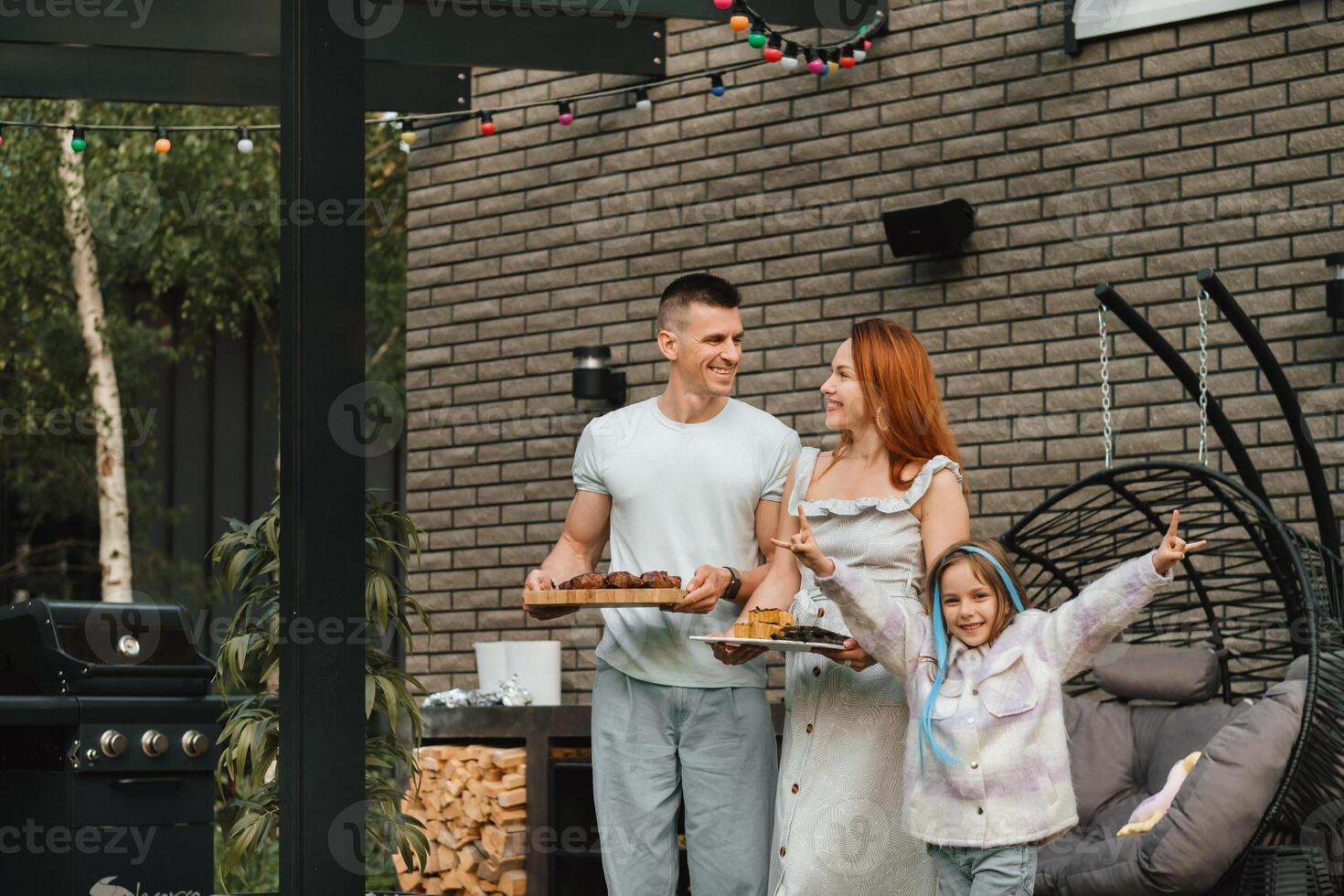 A happy family has prepared lunch and will eat at their house. Portrait of a family with food in their hands photo