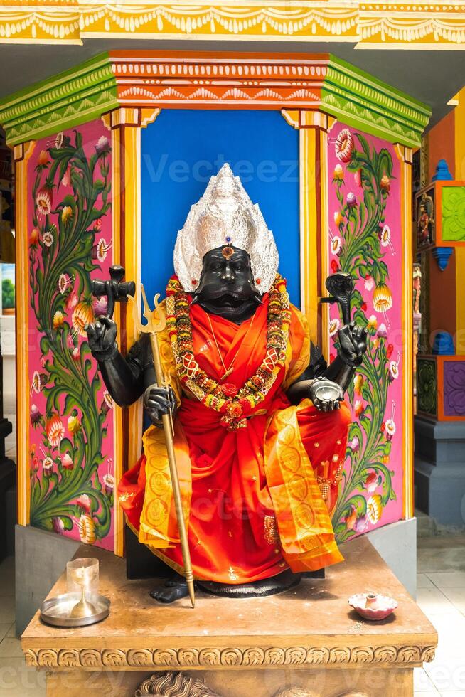 Part of a beautiful and colorful Indian temple in Mauritius Island. Close-up on sculptures and statues of Indian deities photo