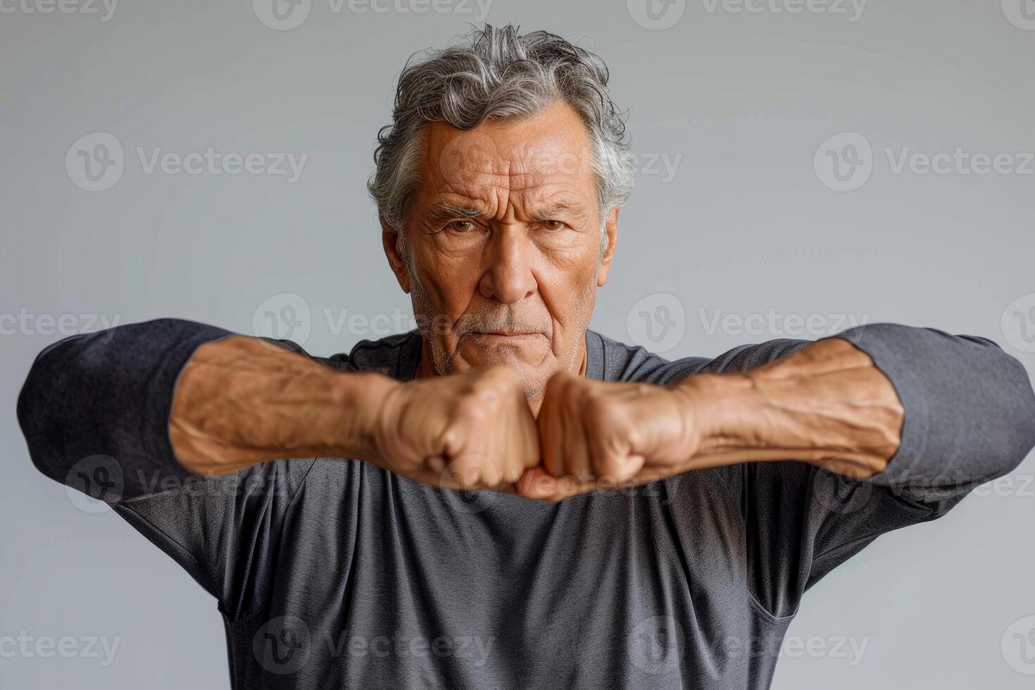 ai generado un atractivo más viejo hombre con un muscular construir en un gris antecedentes foto