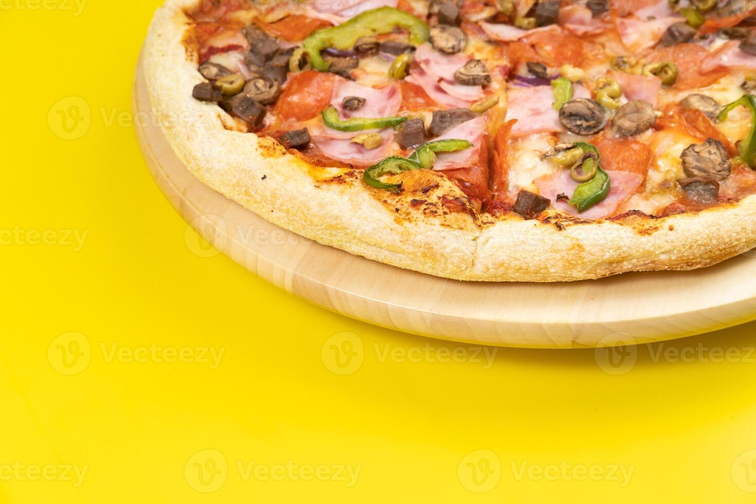 Delicious large pizza with veal and mushrooms on a yellow background photo