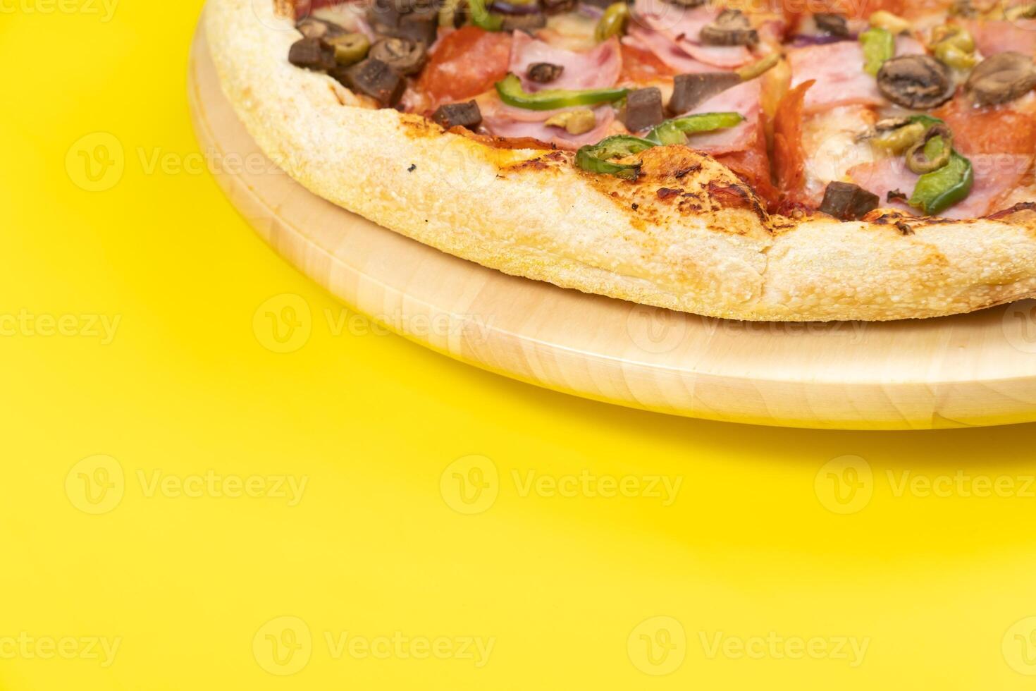 Delicious large pizza with veal and mushrooms on a yellow background photo