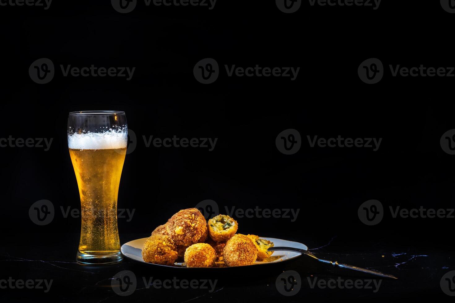 cheese balls with garlic and dill inside for a snack with a glass of beer photo