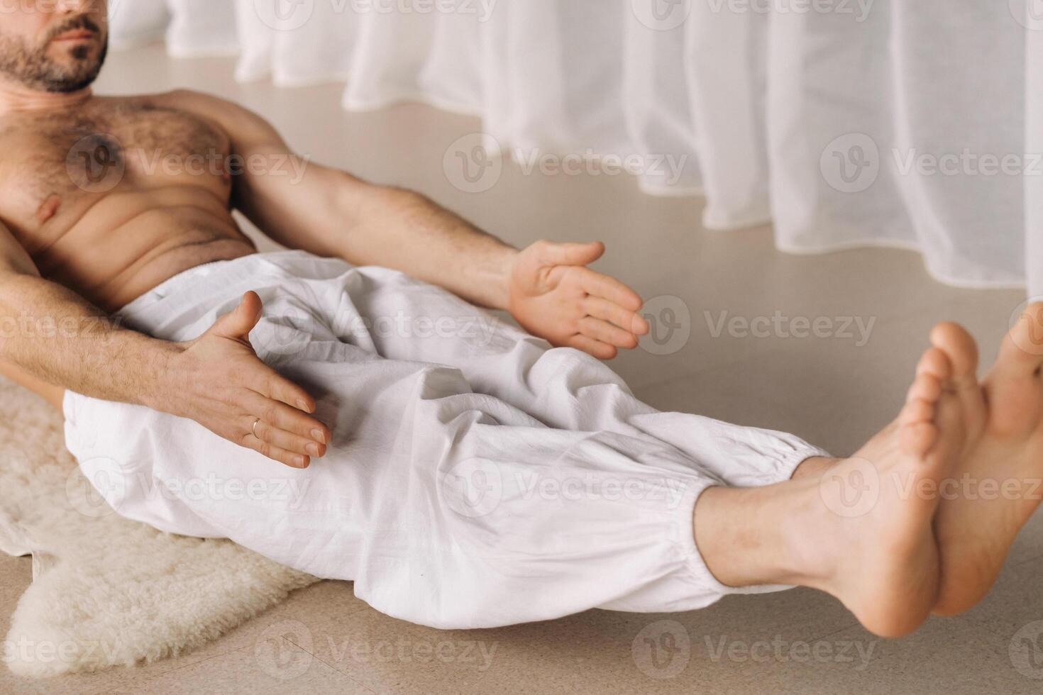 un hombre con un desnudo torso lo hace yoga en un aptitud habitación. el concepto de un sano estilo de vida foto