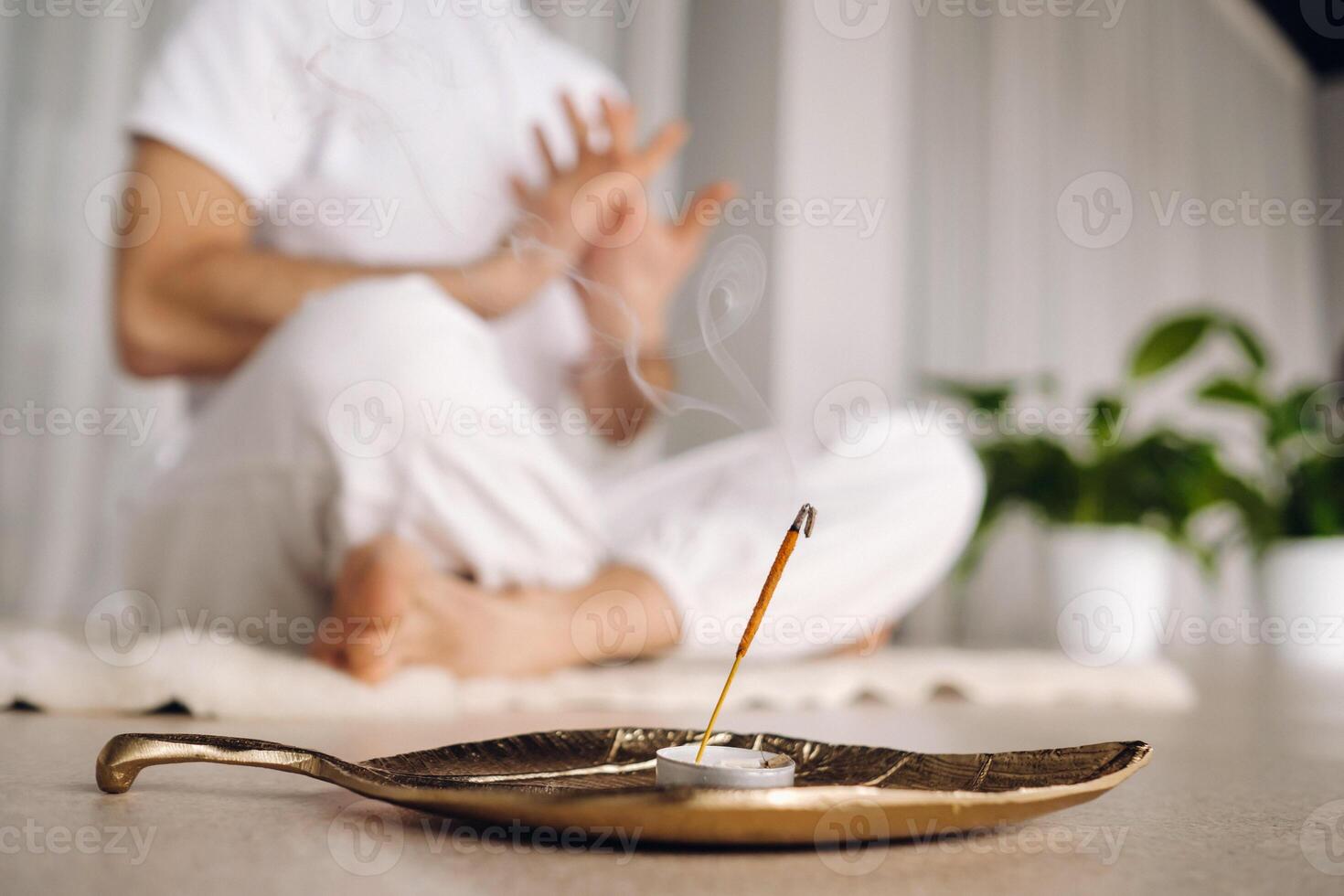 de cerca de un hombre en blanco ropa de deporte haciendo yoga en un aptitud habitación con un balgovón. el concepto de un sano estilo de vida foto