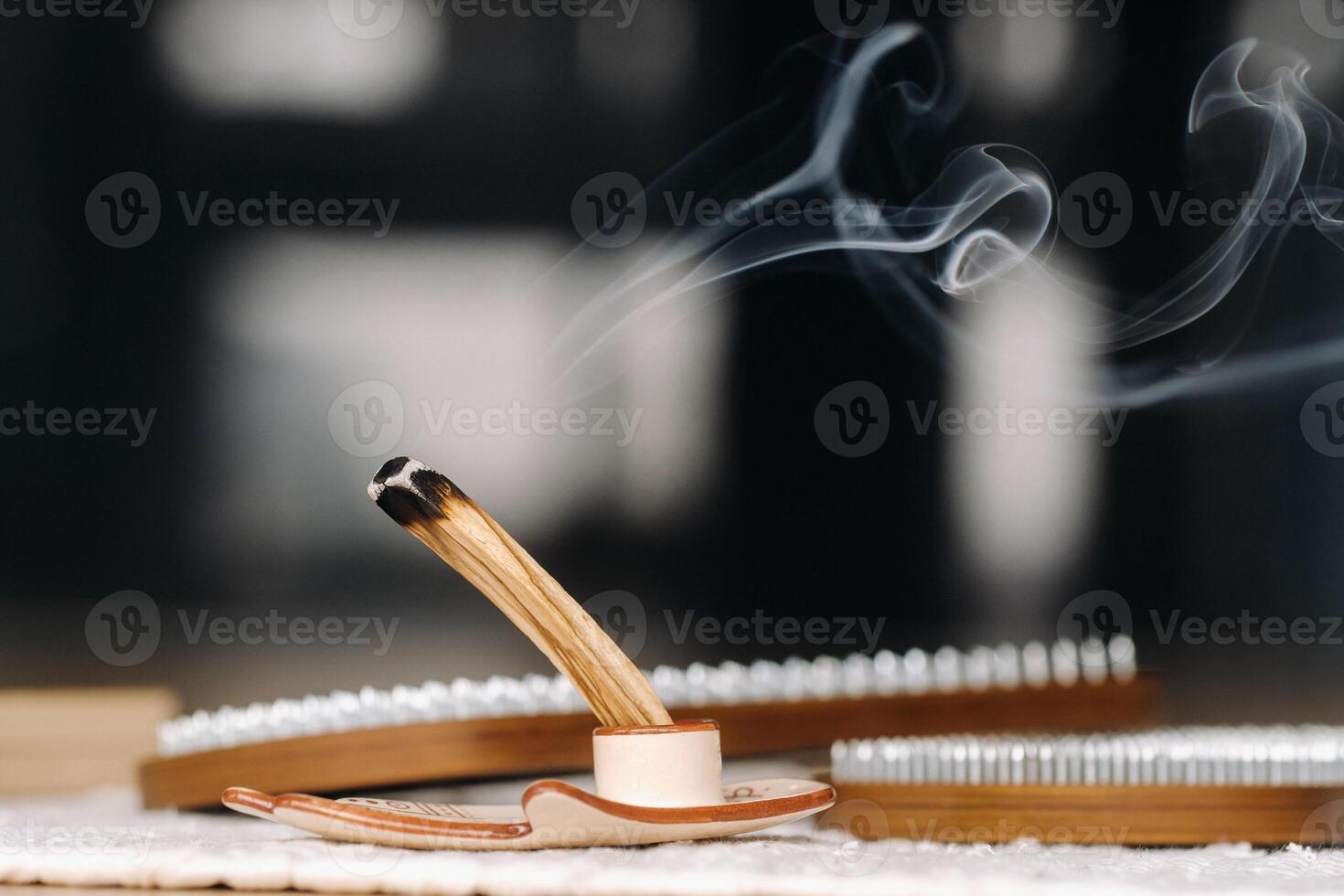 A smoking Palo Santo stick and boards with nails for yoga classes photo