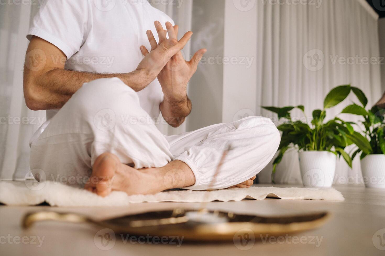 de cerca de un hombre en blanco ropa de deporte haciendo yoga en un aptitud habitación con un balgovón. el concepto de un sano estilo de vida foto