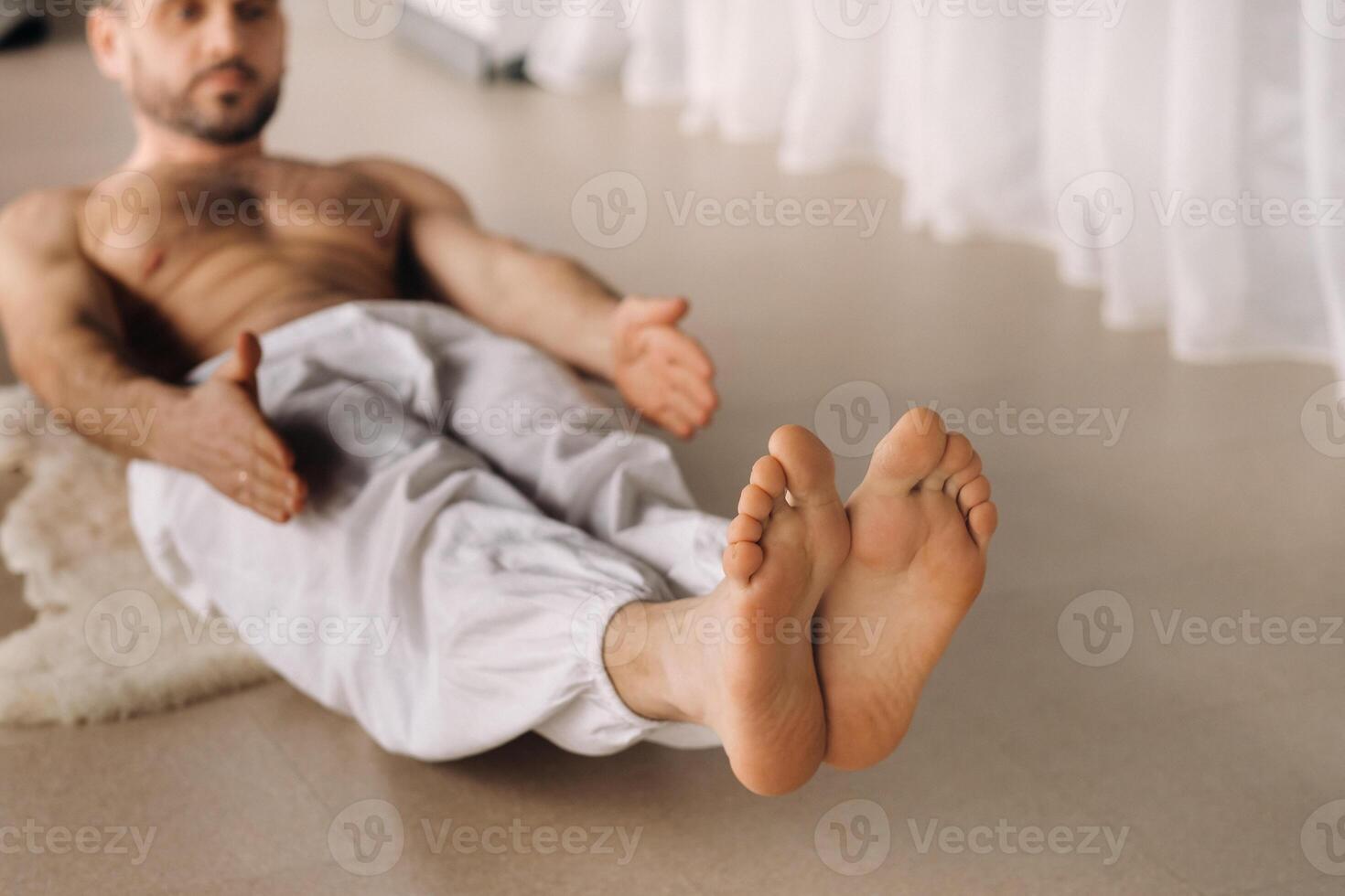 a man with a bare torso does yoga in a fitness room. the concept of a healthy lifestyle photo