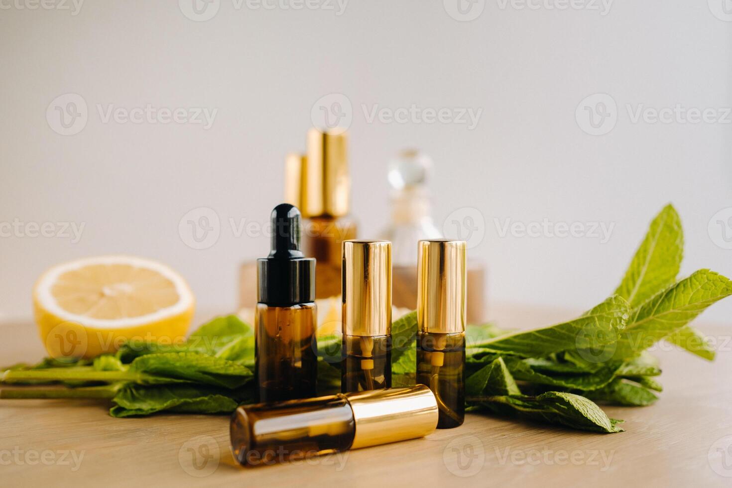 Essential oil in bottles with lemon and mint fragrance lying on a wooden surface photo