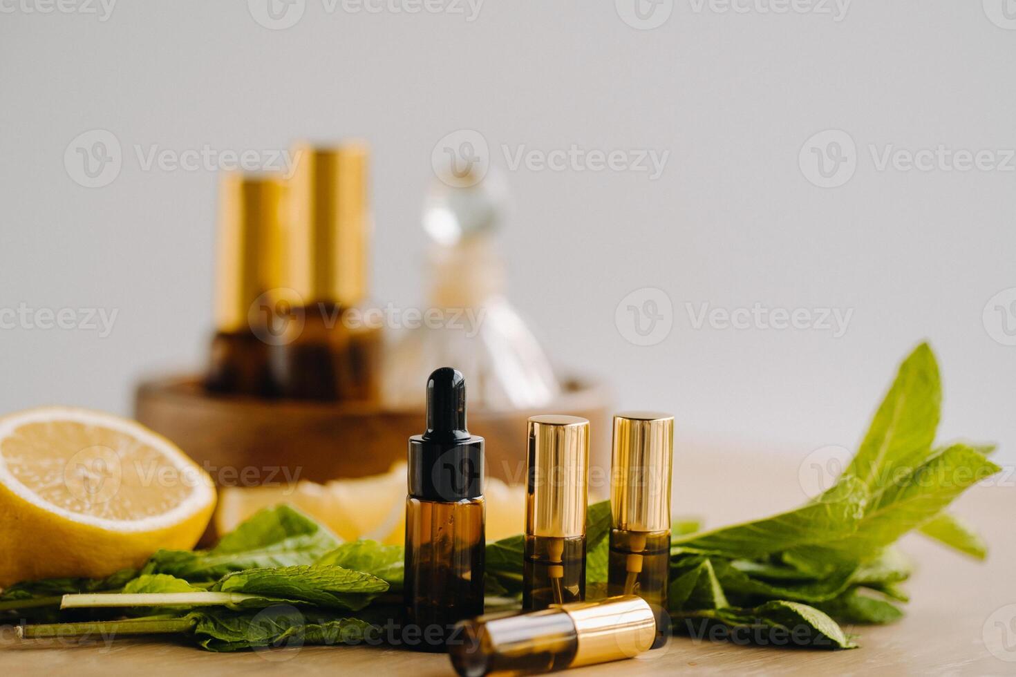 esencial petróleo en botellas con limón y menta fragancia acostado en un de madera superficie foto