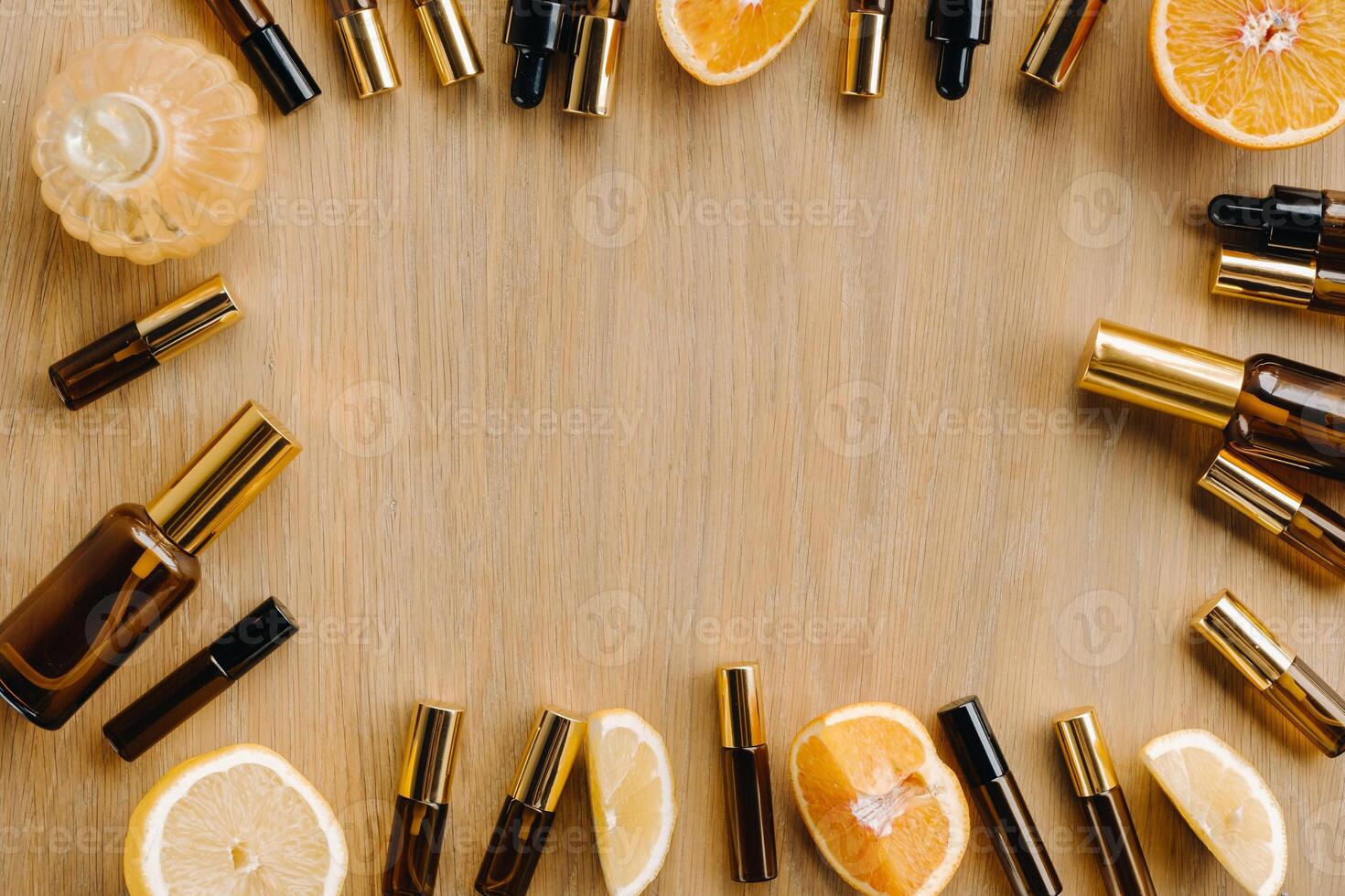 Essential oil in bottles and lemons, oranges lying on a wooden surface photo