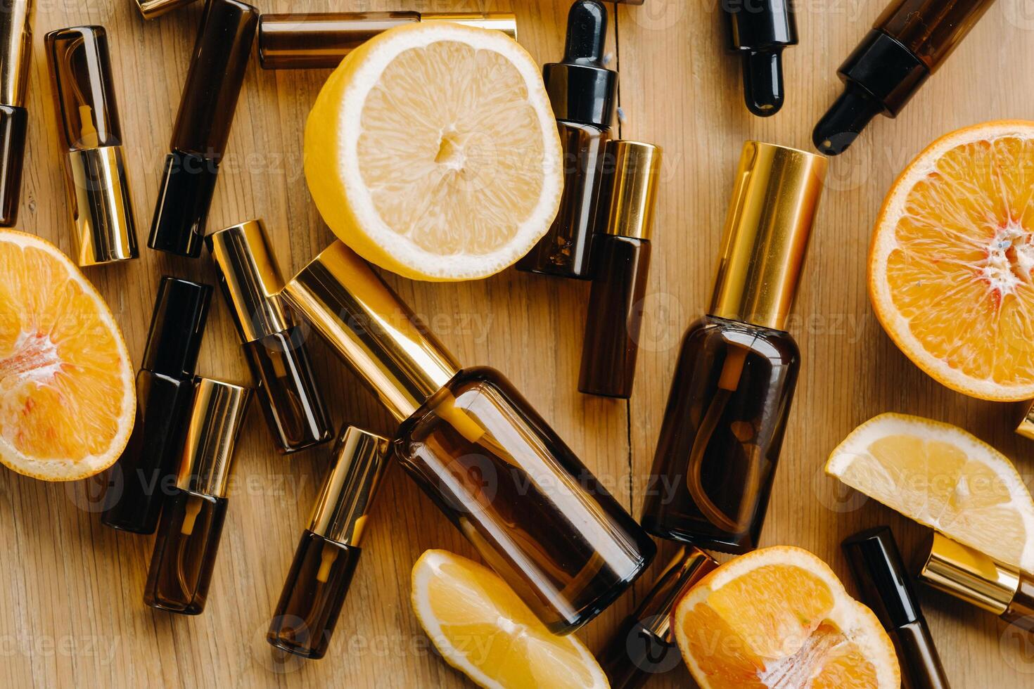 esencial petróleo en botellas y limones, naranjas acostado en un de madera superficie foto