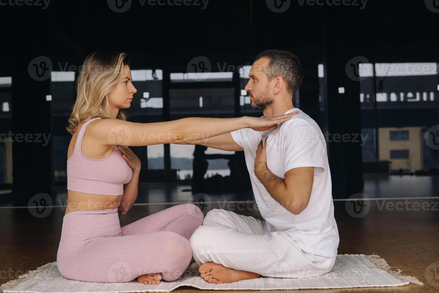 a woman and a man are engaged in pair gymnastics yoga in the gym photo